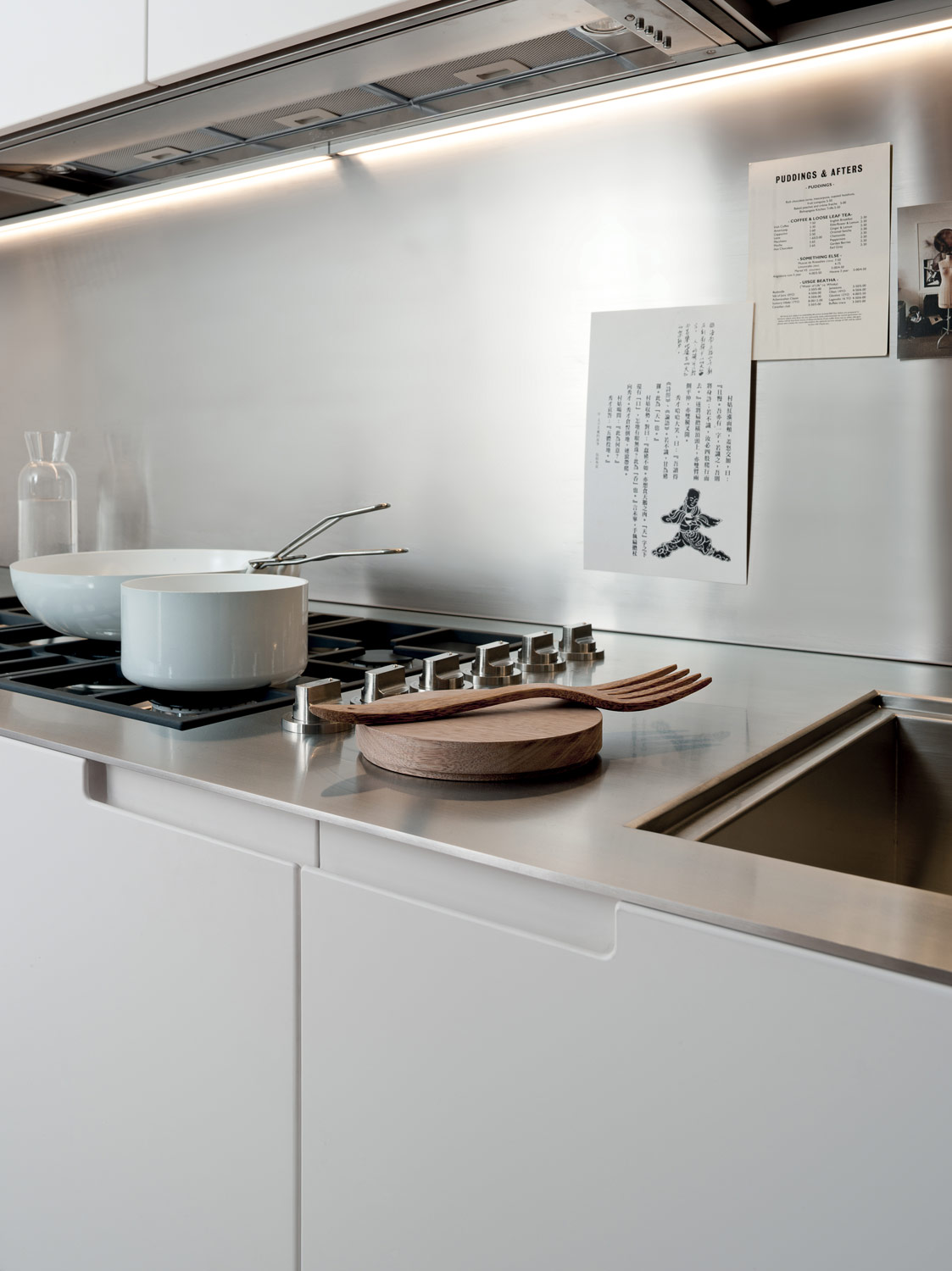 Kuhinje po meri - ideje za kuhinje - bela kuhinja sa stolom - ukupana rucica - tanka radna ploca - potpuno ugradni aspirator koji se ne vidi